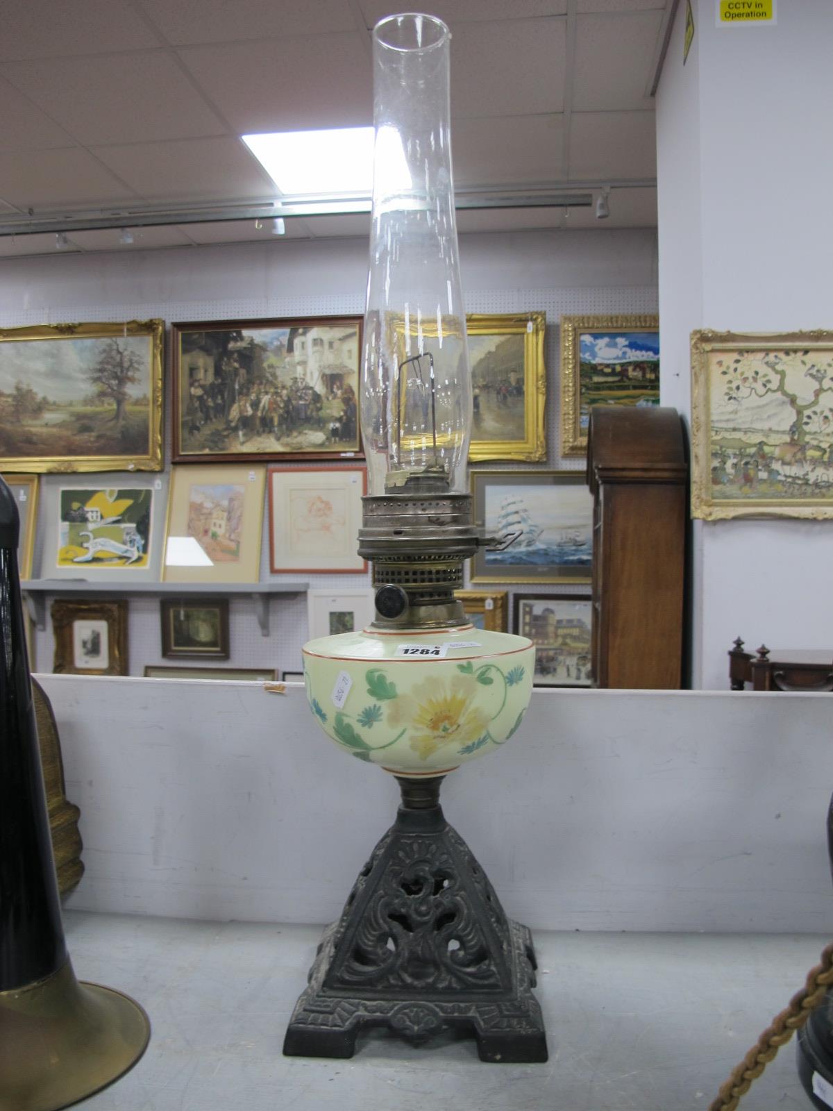 A Late XIX Century Oil Lamp, the opaque glass reservoir painted with flowers, raised on a pierced