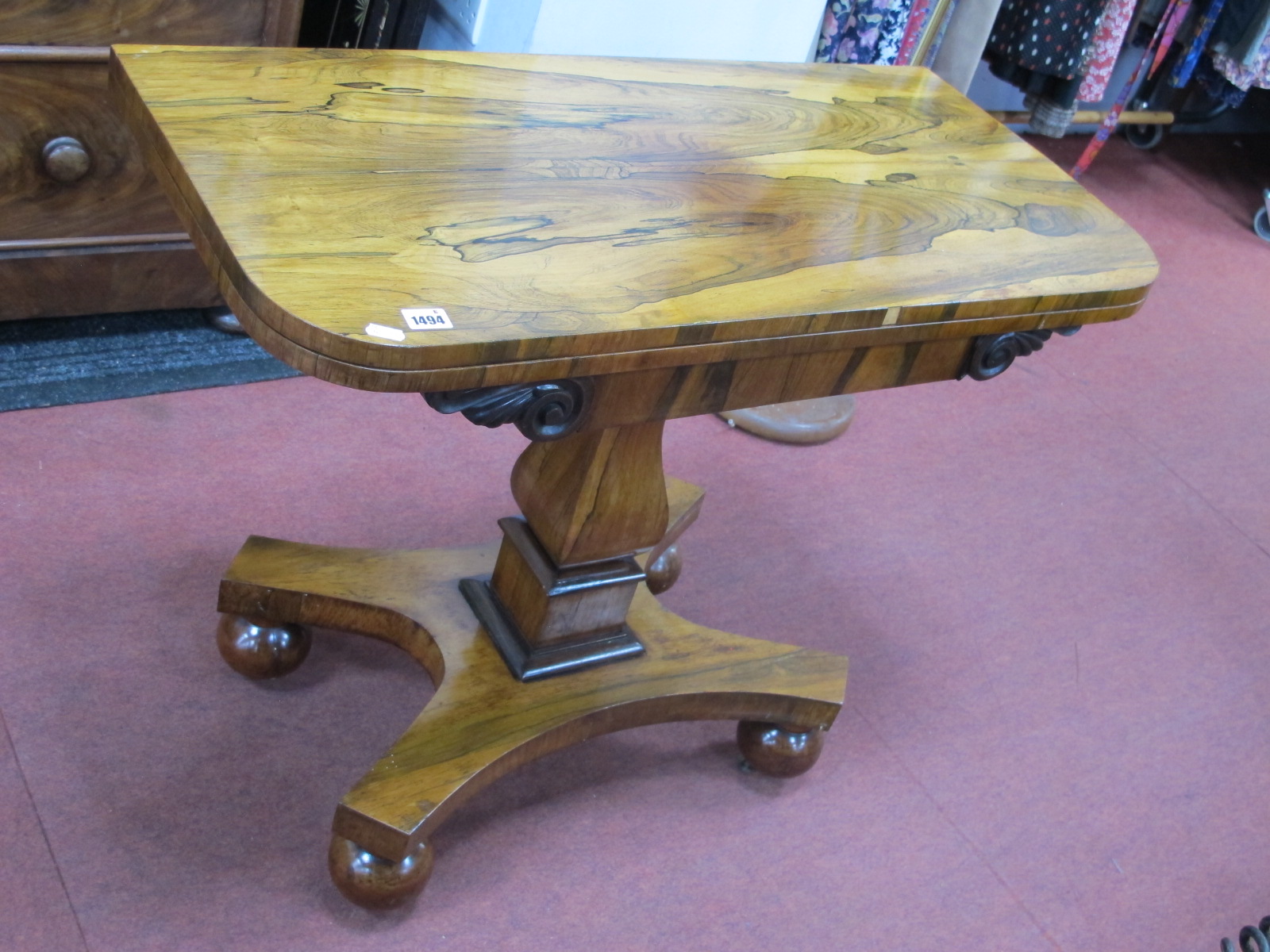 A XIX Century Rosewood Card Table, the fold-over top with baized interior, raised on bulbous and