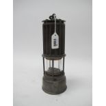 Miners Lamp, the Premier Lamp, Leeds, with corrugated upper body, 26cm high with handle down.
