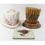 A Victorian Majolica flower pot and stand, a cheese stand and cover and a Victorian tile
