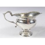 A silver milk jug with scrollwork border, Birmingham 1905, makers mark William Aiken, 95g