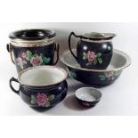 An Edwardian five piece toiletry set decorated roses on a black ground