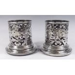 A pair of Asprey silver plated bottle holders with pierced leaf and flower decoration, base 13cm