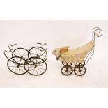 A vintage wicker dolls pram with composition rabbits head to front and a pram base