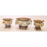 A garniture of three large pottery jardinieres with applied floral decoration and elaborate gilt