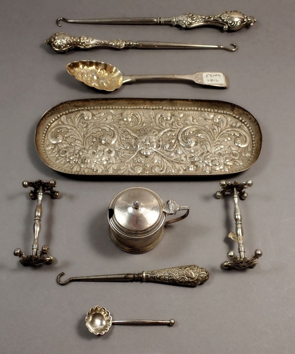 A silver embossed trinket tray with embossed bacchus decoration, London 1890, 85g and three silver