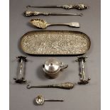 A silver embossed trinket tray with embossed bacchus decoration, London 1890, 85g and three silver