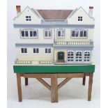 A large dolls house circa 1923, by Triang with Hamleys label, 107 x 49 x 85cm plus wooden stand