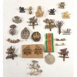 A tin containing various Welsh military insignia, R.W.F Herefordshire regiment, Silver Monmouth