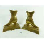A pair of brass shoe form miniature fire dogs, 14cm high