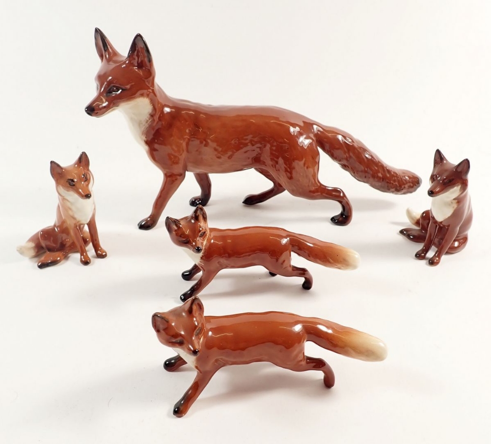 A large Beswick fox and four smaller Beswick foxes, largest fox measures approx 13cm high