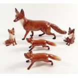 A large Beswick fox and four smaller Beswick foxes, largest fox measures approx 13cm high