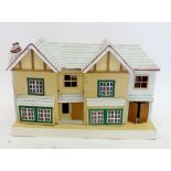 A small early 20th century painted wooden dolls house, 68cm wide and contents