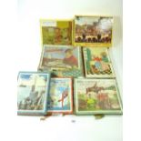 A group of old wooden jigsaws, boxed