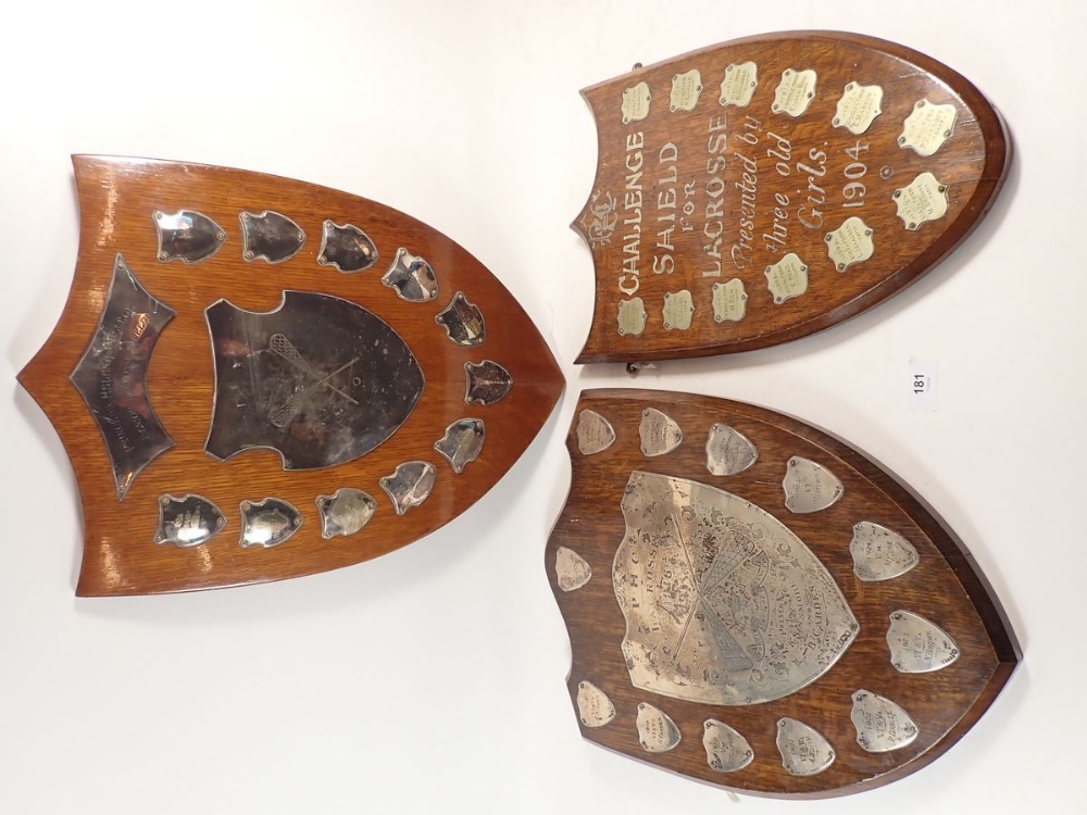 An oak lacrosse shield from Princess Helena College set with silver plaques and two similar, with