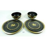 Two Chinese export black and gilt lacquer bowls and two plates painted Kylin lions