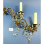 A pair of brass scrollwork oval wall lights with cut glass drops, 20cm wide