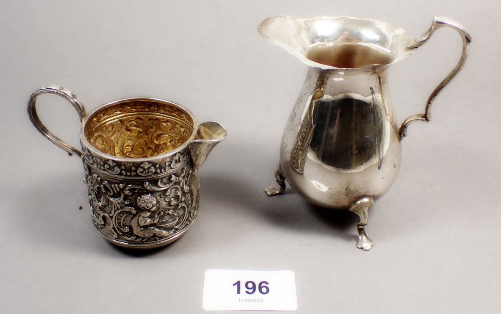A Victorian silver cream jug with embossed cherub and scrollwork decoration, Chester 1898 and a