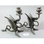 A pair of cast metal dragon form candle holders, 19cm high