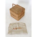 A vintage wicker sewing basket and contents including knitting needle and needle case