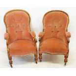 A pair of Victorian mahogany framed button upholstered armchairs with scroll over arms on turned