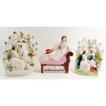 Two Victorian Staffordshire groups of lovers in a bower and a woman reclining on a sofa with