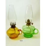 A Victorian orange glass finger lamp and a green one