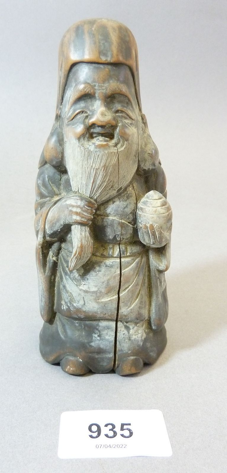 A Chinese 18th or early 19th century carved hard wood figure of an old man holding his beard, 40cm