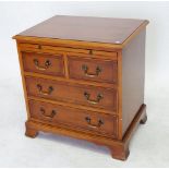 A reproduction yew small bachelors chest with brushing slide over two short and two long drawers