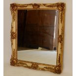 A large gilt and cream framed mirror with shell and flower decoration, 83 x 70cm