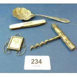 A silver plated corkscrew, sifter spoon, mother of pearl penknife and a miniature silver