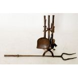 A wrought iron fireside set and a long wrought iron fire fork, signed AK