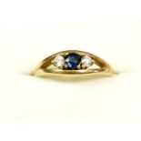 A 9 carat gold ring set sapphire flanked by white stones, size L to M