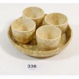 A Ruskin mottled cream set of four egg cups and stand