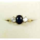 An 18 carat gold ring set sapphire flanked by two diamonds, size L to M, 3g