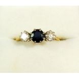 A gold ring set sapphire flanked by two diamonds, size O to P