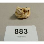 A Japanese Meiji period ivory small netsuke in form of a snake coiled around a frog, signed, 2.3cm