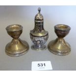 A silver urn form pepper pot and two small candlesticks