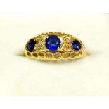 A Victorian 18 carat gold ring set three blue stones flanked by pairs of chip diamonds, size Q to R,