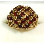 A vintage 9 carat gold garnet ring (one stone deficient) 6.8g