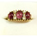 A 9 carat gold ring set three cabochon cut pink stones and six white stones, size S to T