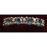 A 9 carat gold ring line set blue topaz and pair of chip diamonds, size O