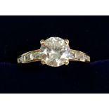 A 14 carat gold dress ring set central white stone on baguette cut shoulders, size O to P