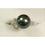 An 18 carat white gold ring set pearl on diamond set shoulders, size O