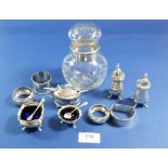 A silver cruet set, three silver napkin rings, mustard pot and a cut glass jar with silver collar