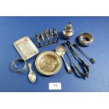 A box of silver and white metal including toast rack, sugar tongs etc.