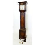 A oak cased grandmother clock with steel face flanked by barleytwist supports