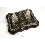 A Victorian papier mache desk stand with stamp box and pen trays fitted two cut glass inkwells, 30 x