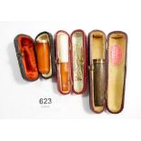 Two amber cigarette holders and an ebony one inlaid white metal - all cased