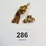 Two yellow metal charms in form of a tassel, 4.5g, and a boot that opens 2.2g